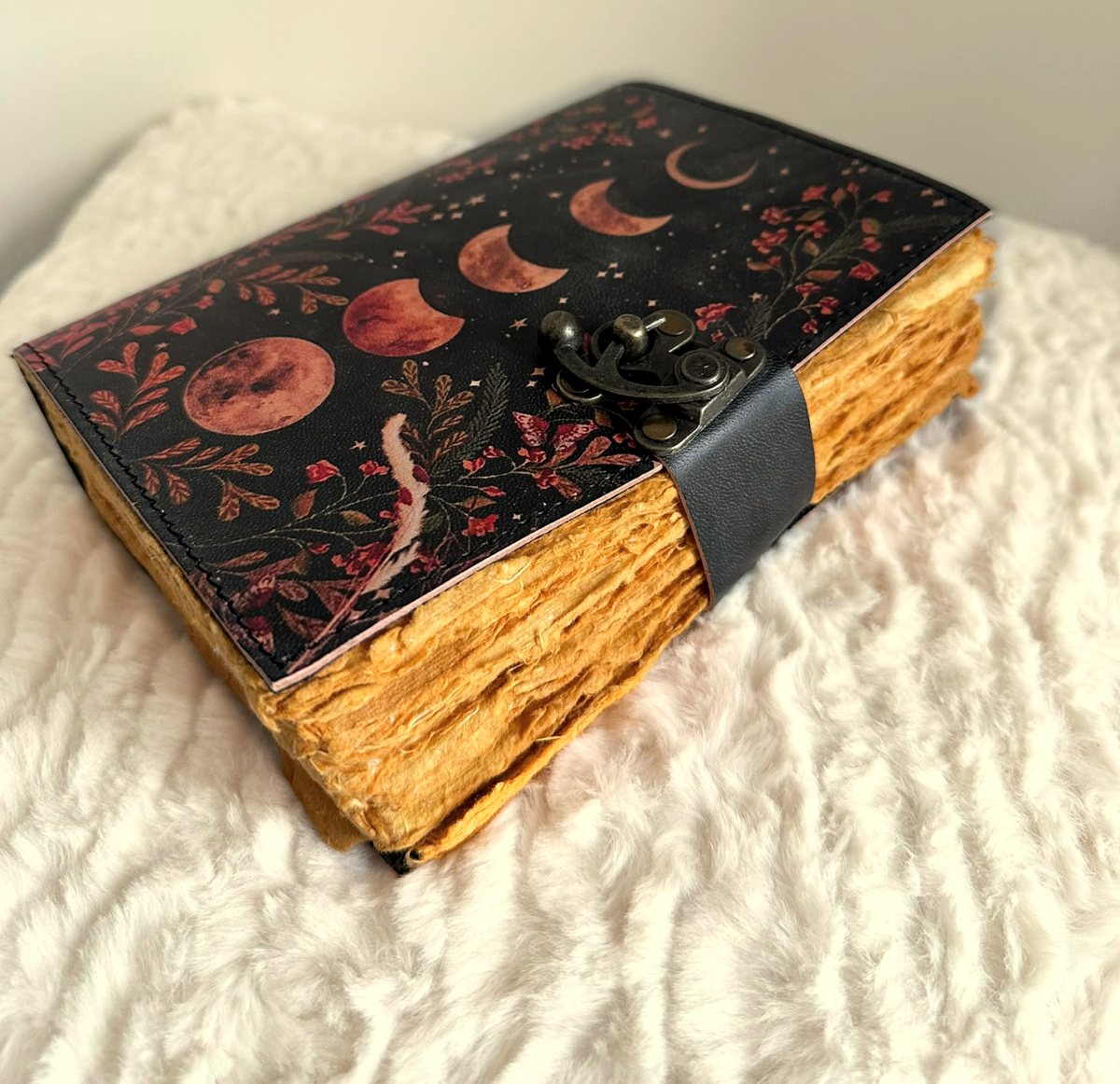 A leather bound journal with moon phases and handmade pages in the Healice studio