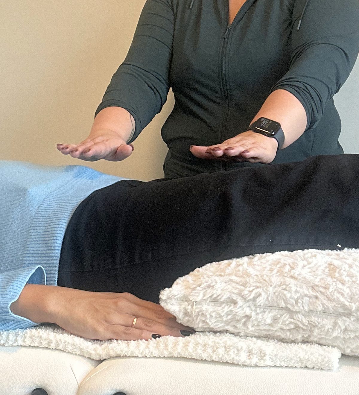 Alice holding her hands over a client during a Reiki session